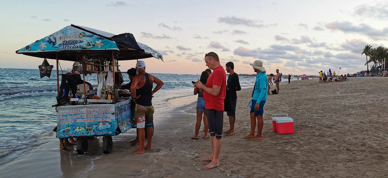 Motorized drink cart on the very shore, selling pina coladas out of actual pineapples